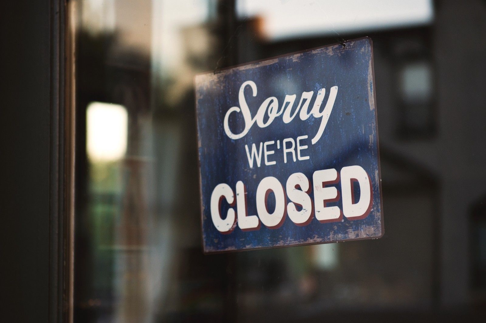 close up of a sign that says "Sorry we're closed" hanging in a window