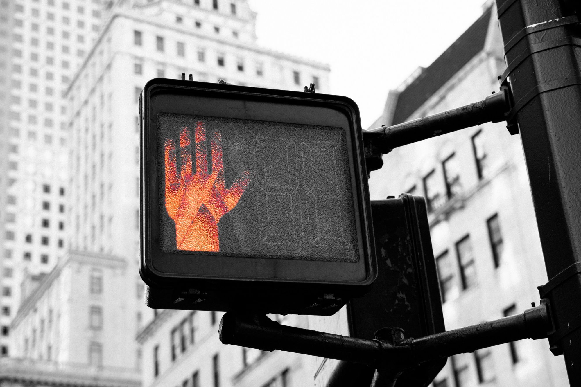 United states black and white photo of a pedestrian signal white the stop hand signal colored orange